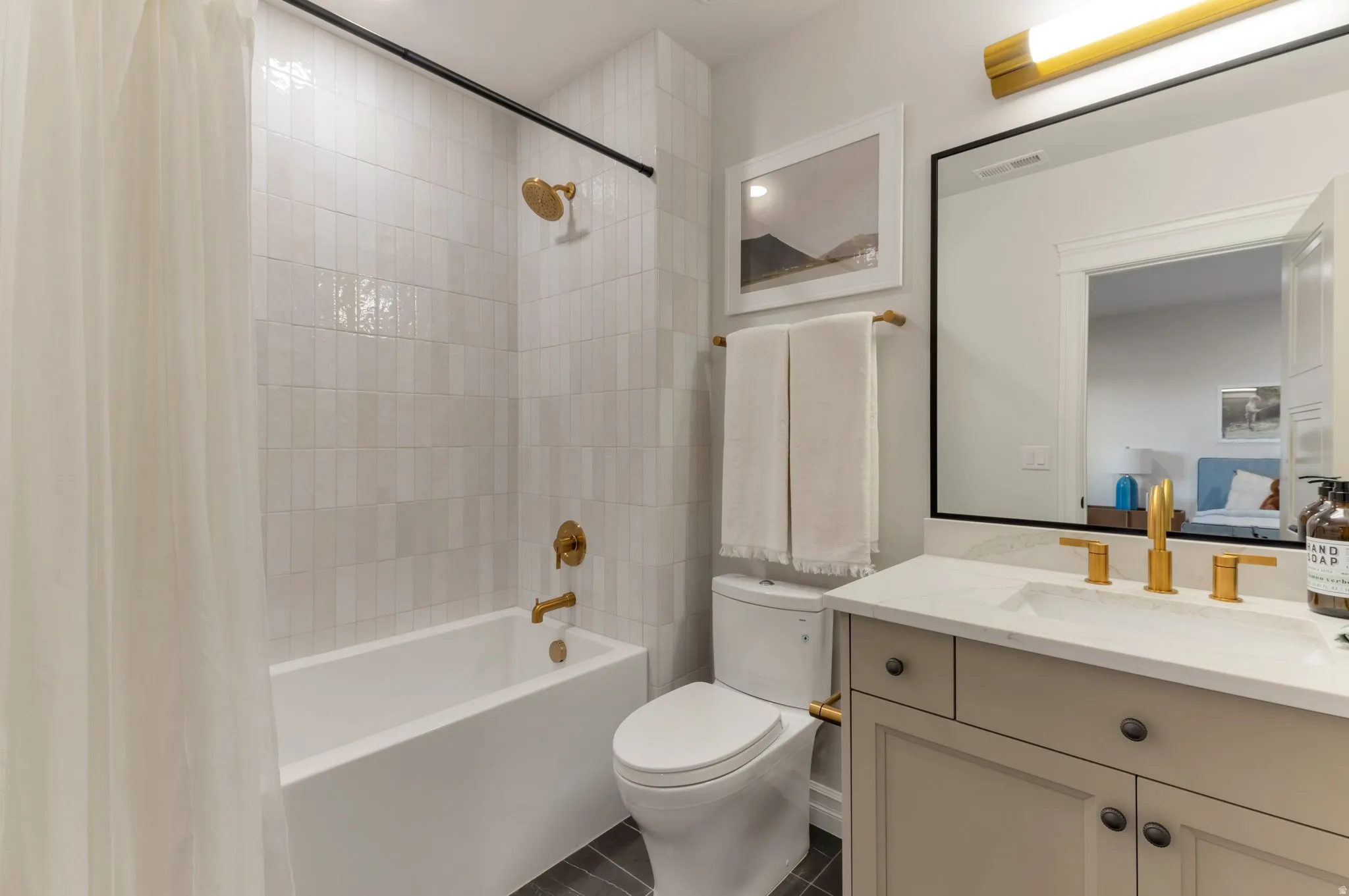 Full bath with shower / bath combination with curtain, vanity, ensuite bathroom, and dark tile patterned floors