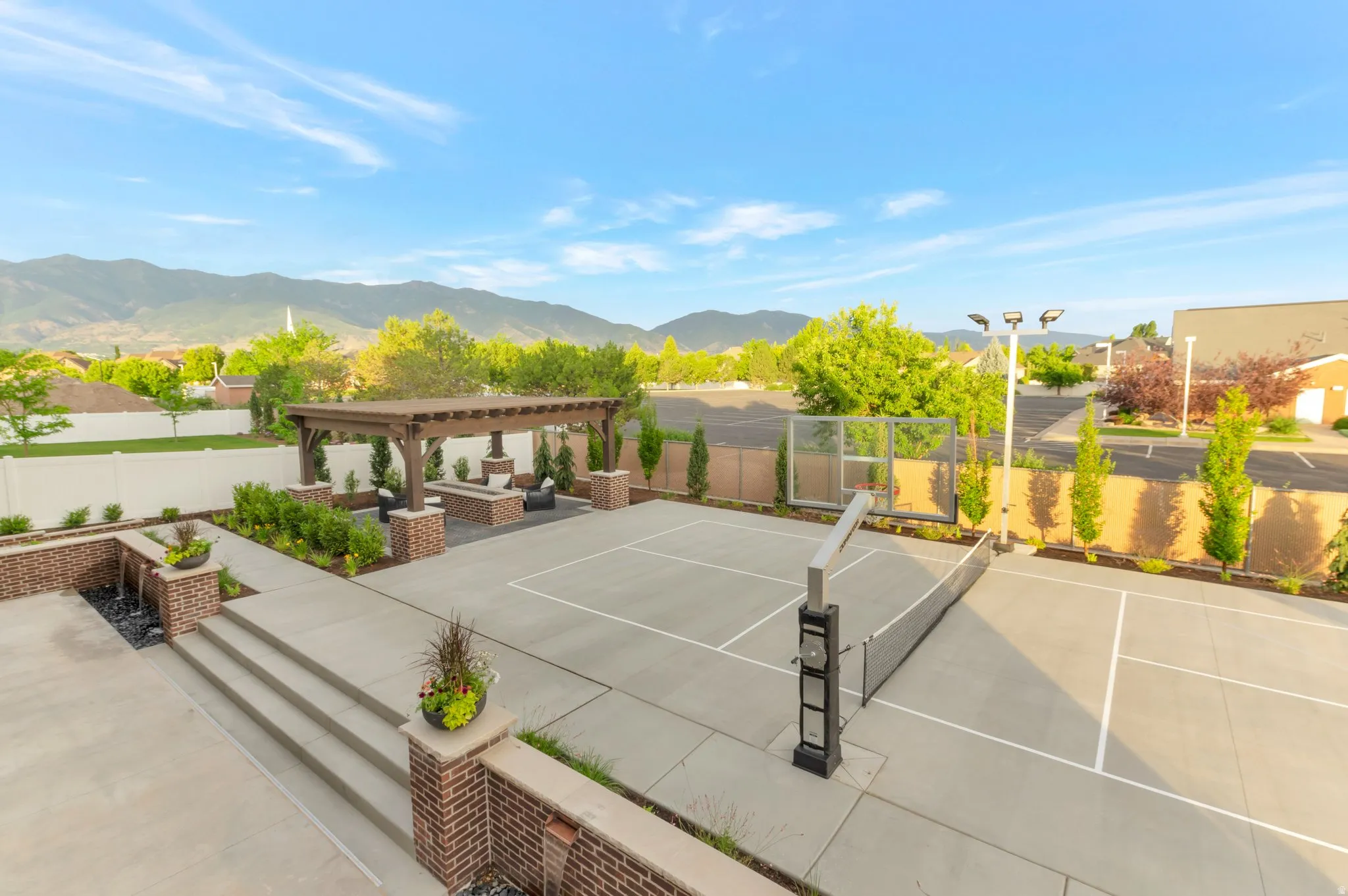 View of tennis court with a fenced backyard, a pergola, a patio area, a mountain view, and outdoor seating