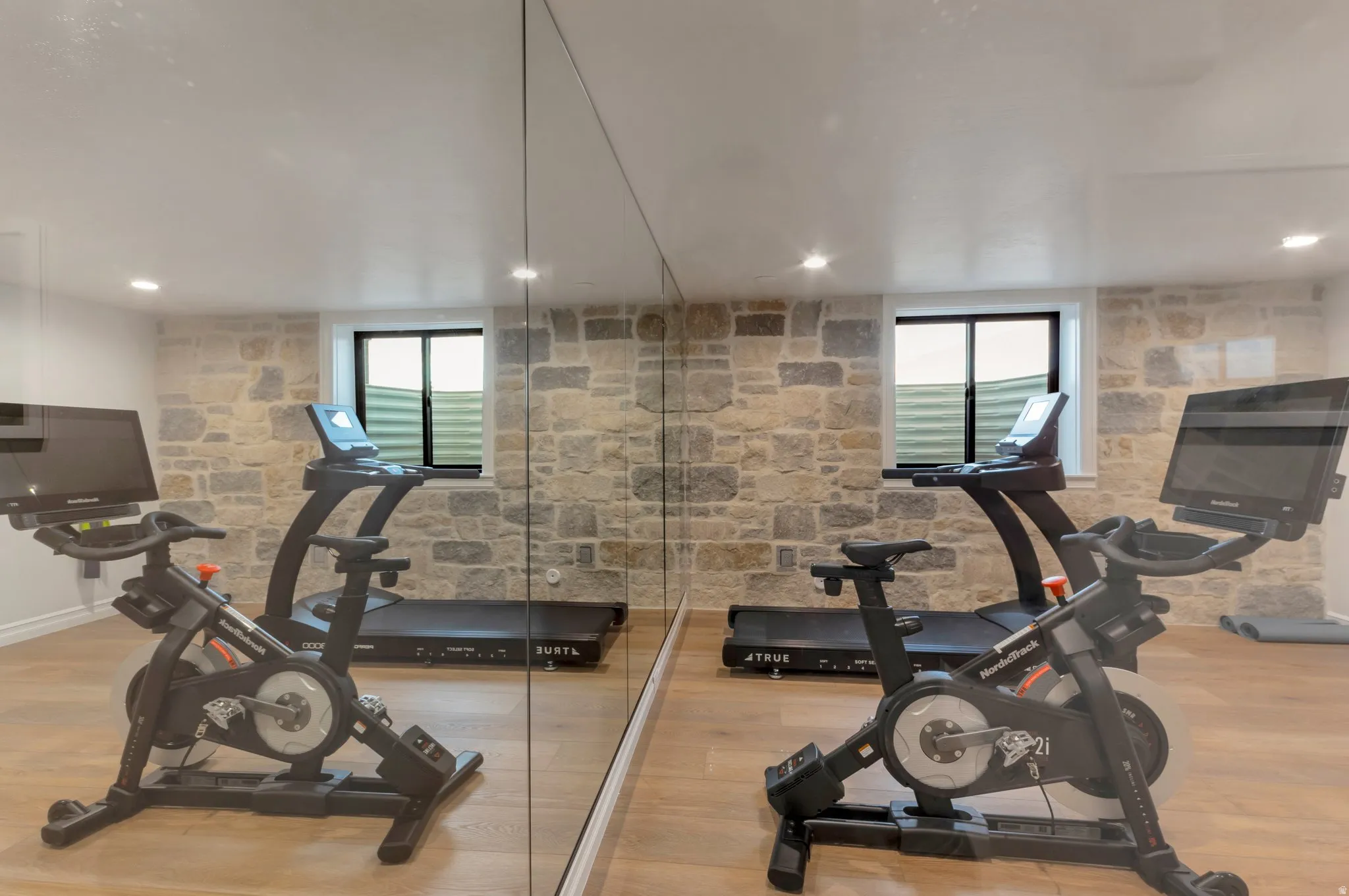 Exercise room with light wood-style flooring