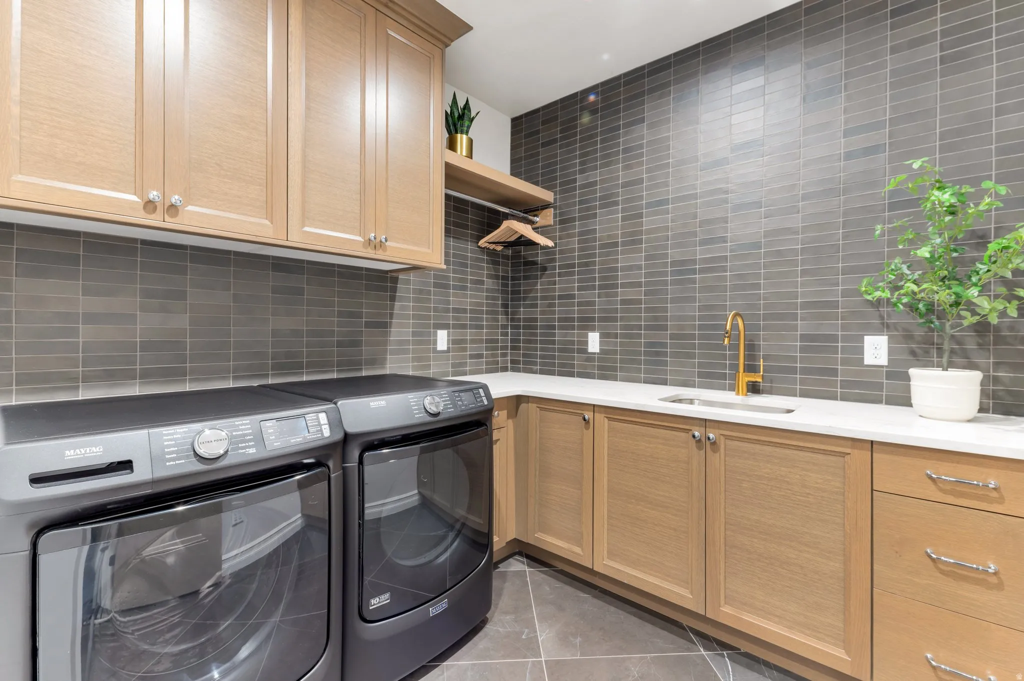 Laundry room featuring washer and clothes dryer, cabinet space, and light tile patterned flooring