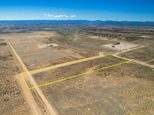 Overview of rural landscape with property parcel outlined and a mountainous background