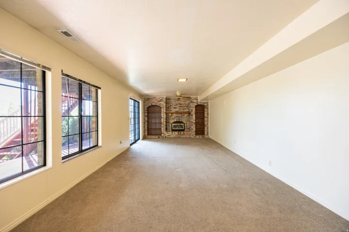 Basement family room with fireplace, built in shelving and walkout door.