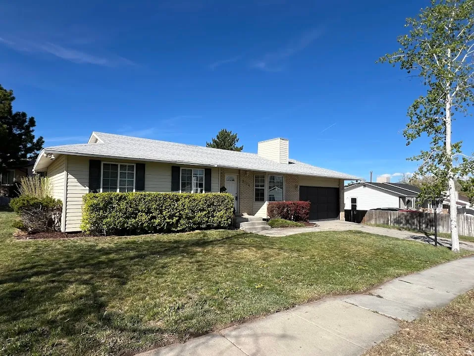 Ranch-style house with a garage, concrete driveway, and a chimney