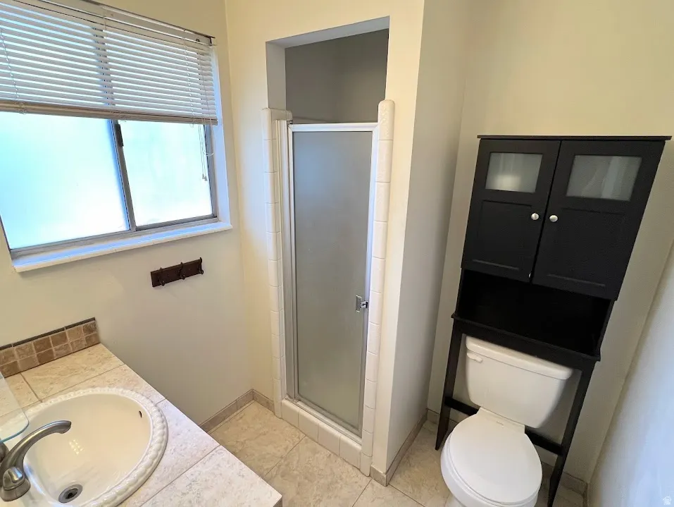Full bathroom featuring vanity, a shower stall, and light tile patterned floors