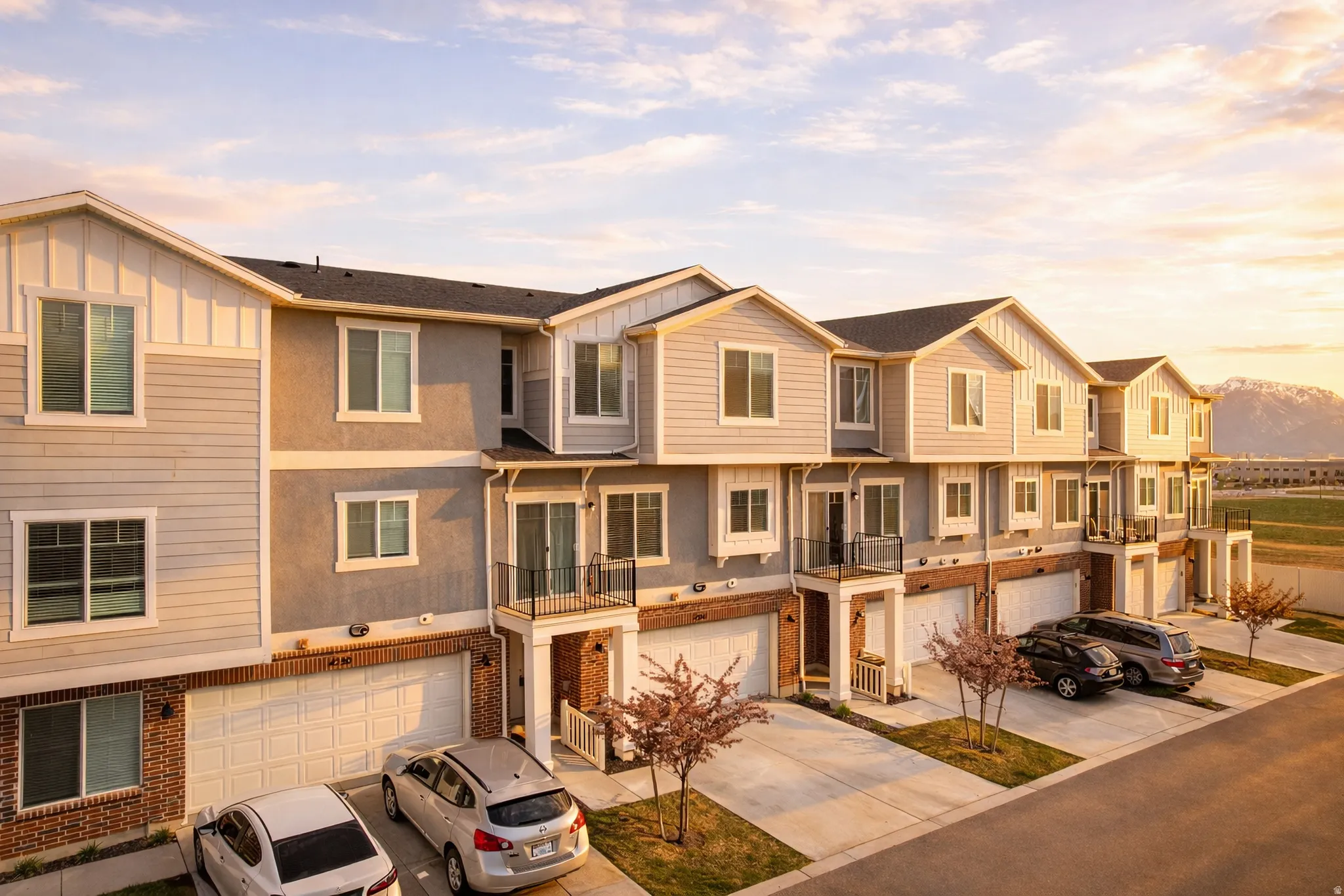 View of front facade with a residential view, brick siding, driveway, and a balcony