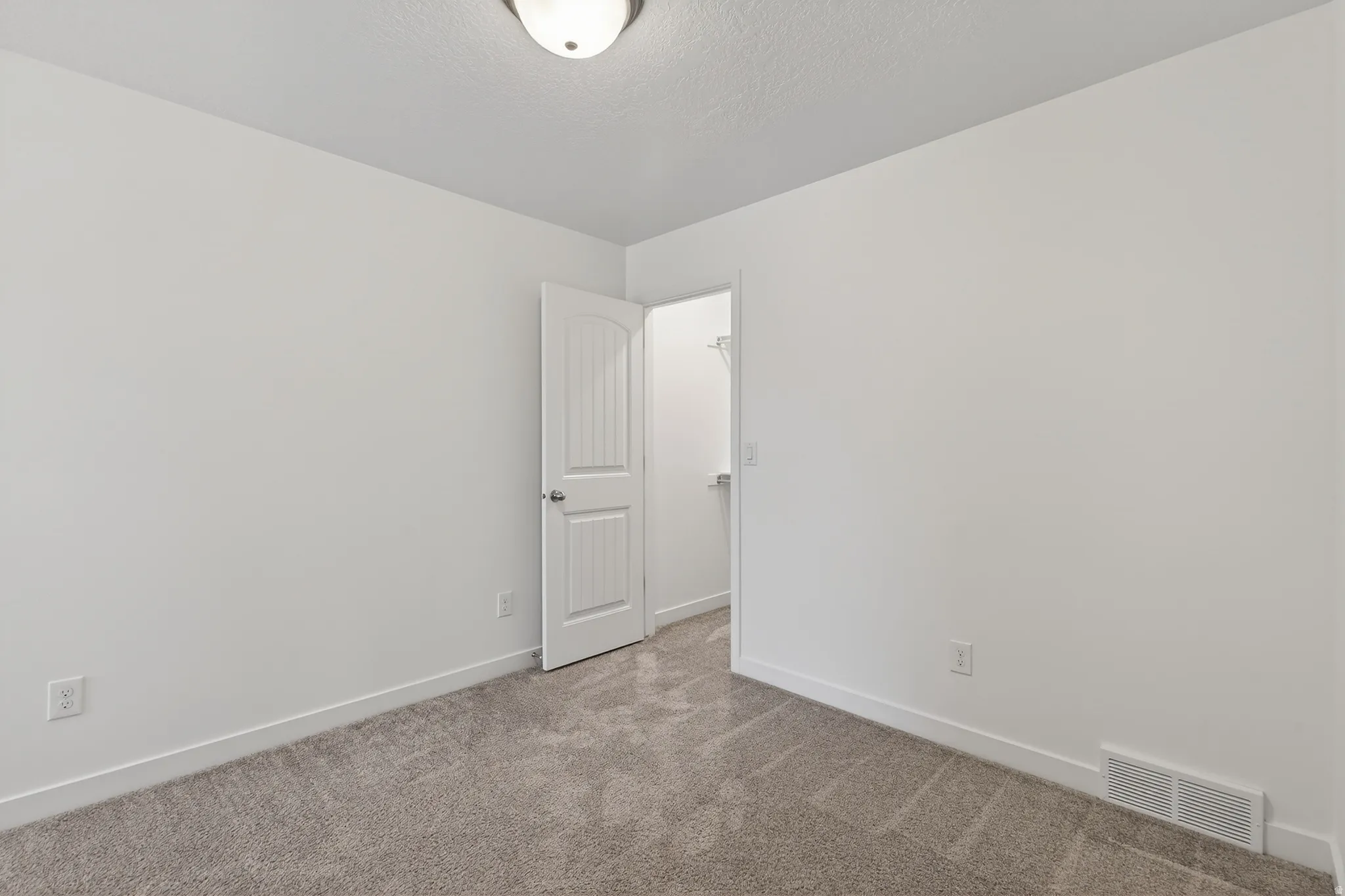 Unfurnished room featuring carpet and a textured ceiling