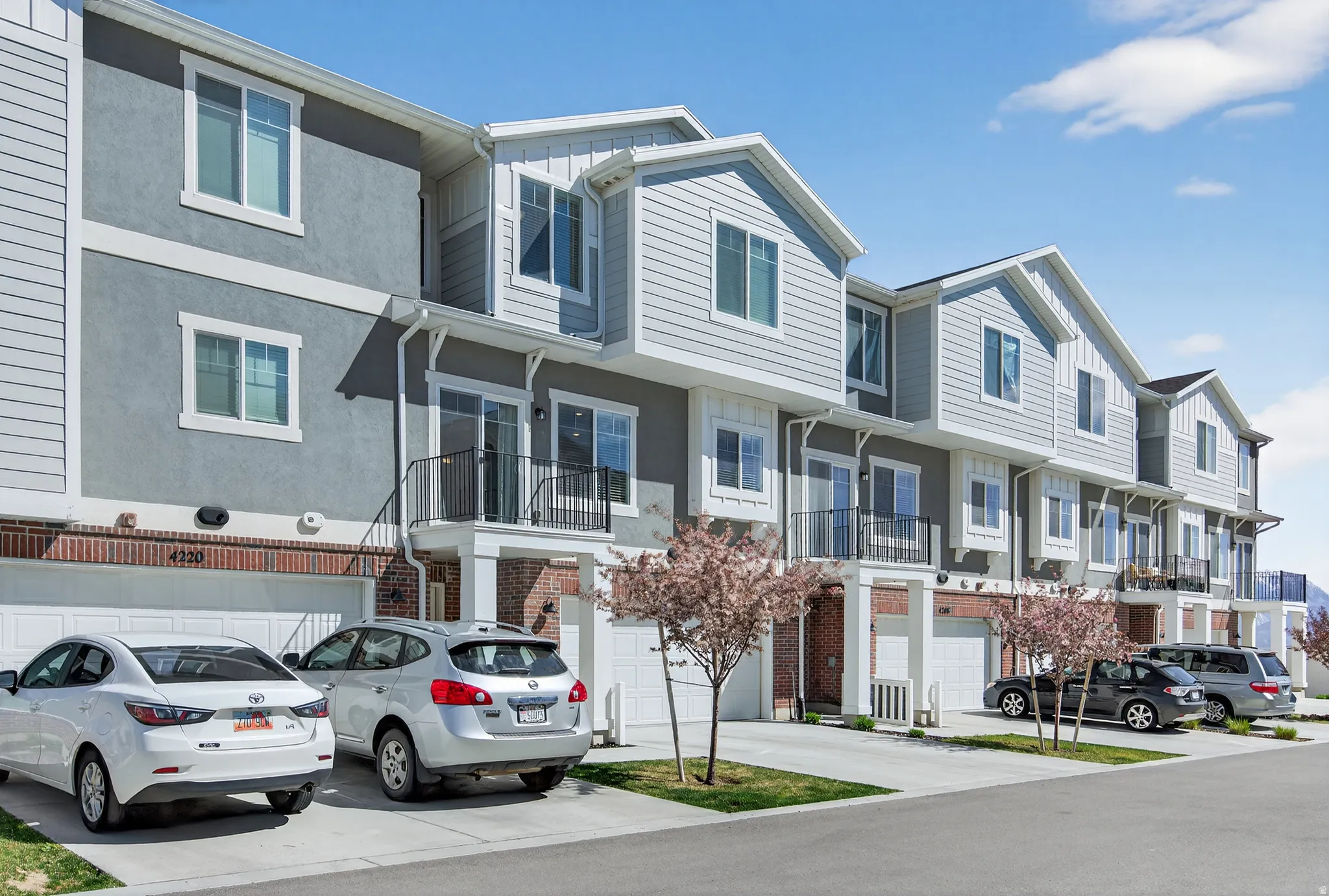 Traditional-style house featuring a residential view, driveway, a garage, and stucco siding