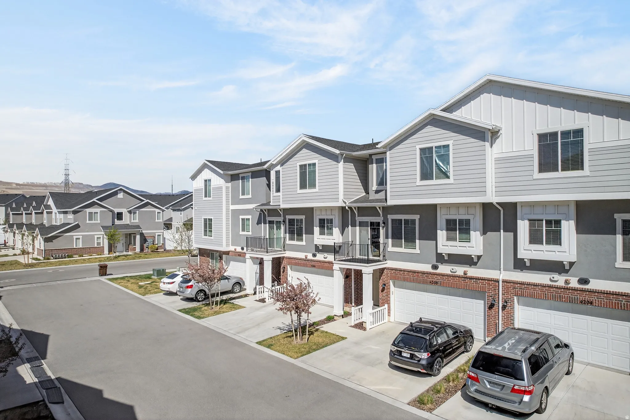 View of front of house featuring a residential view, board and batten siding, a garage, concrete driveway, and brick siding