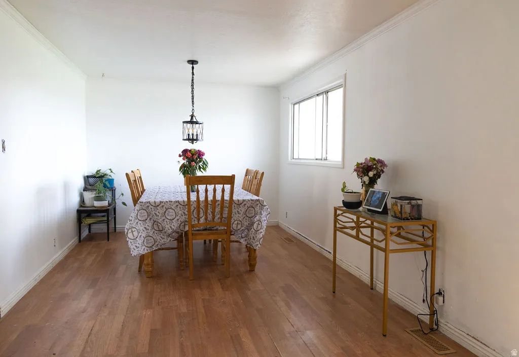 Dining area featuring wood finished floors and ornamental molding