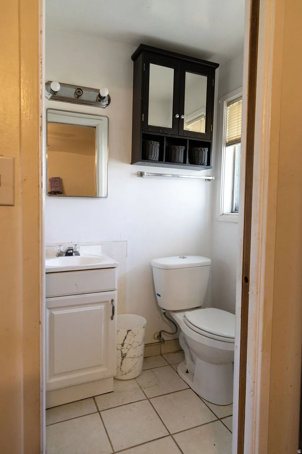 Half bath featuring vanity and light tile patterned flooring
