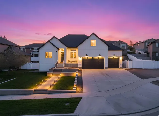 Modern farmhouse featuring board and batten siding, driveway, a residential view, and a garage