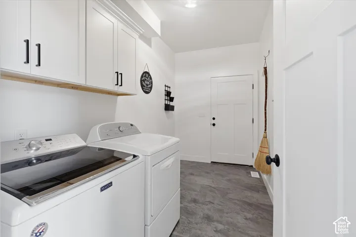 Laundry room featuring separate washer and dryer and cabinet space