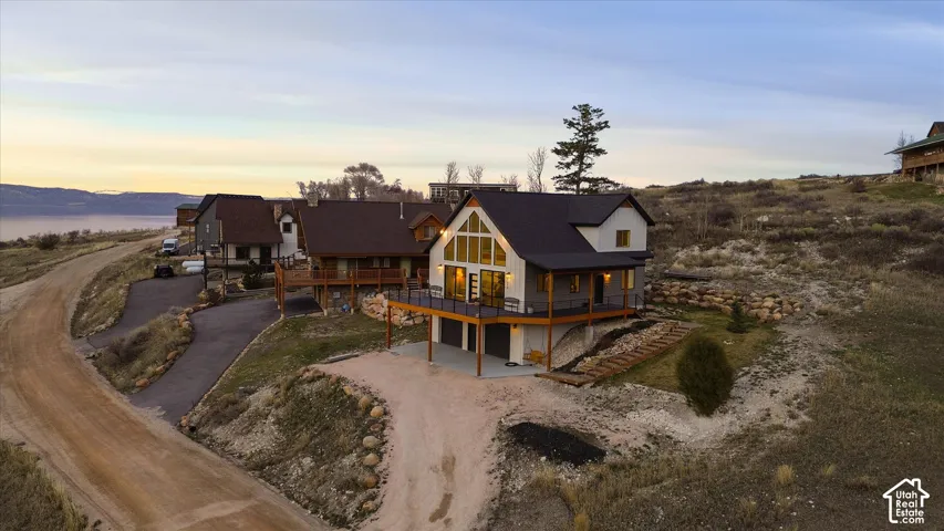 View of front of house featuring dirt driveway, a garage, and covered porch