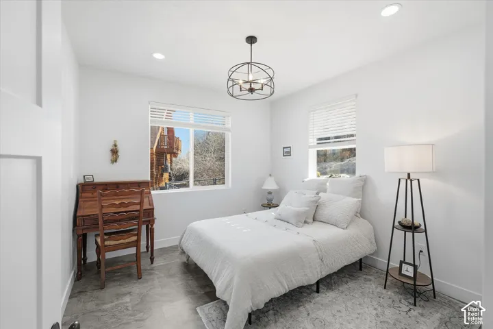 Bedroom featuring baseboards and a chandelier