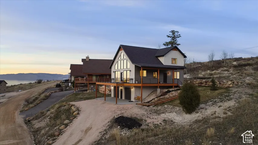 View of front of house featuring an attached garage, a patio, driveway, and a deck with mountain view