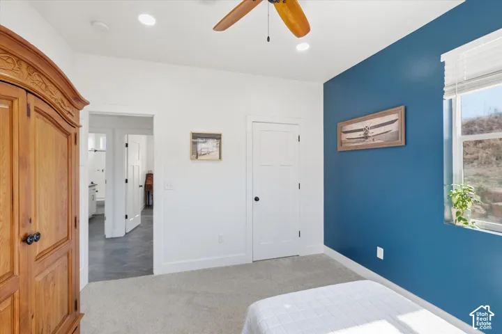 Bedroom with light colored carpet, a ceiling fan, a closet, and recessed lighting
