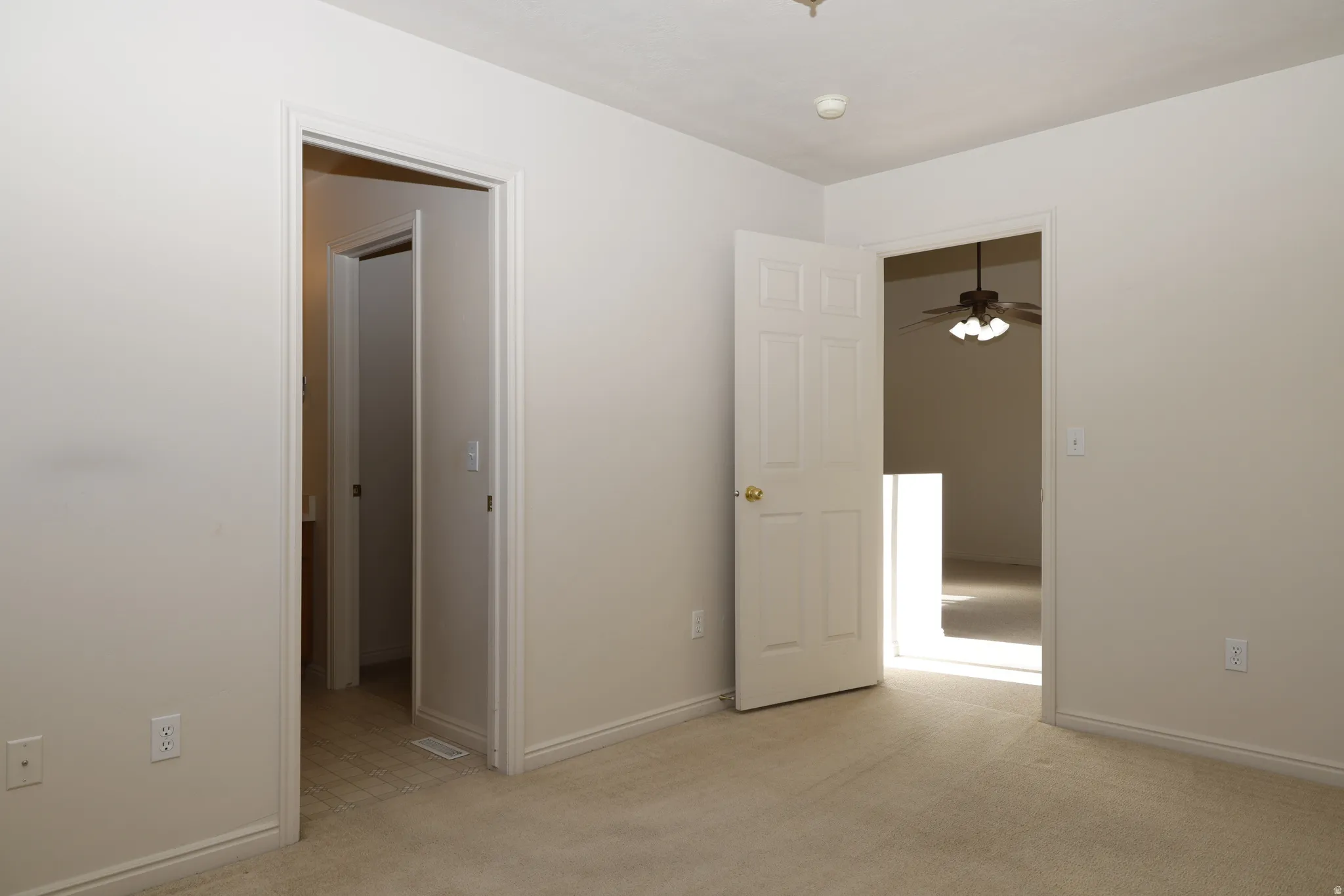 Unfurnished bedroom featuring light colored carpet and baseboards