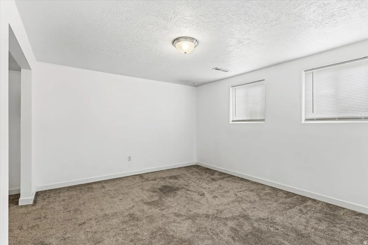 Spare room featuring a textured ceiling and carpet flooring