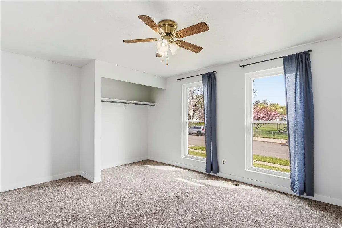 Unfurnished bedroom featuring carpet and a ceiling fan