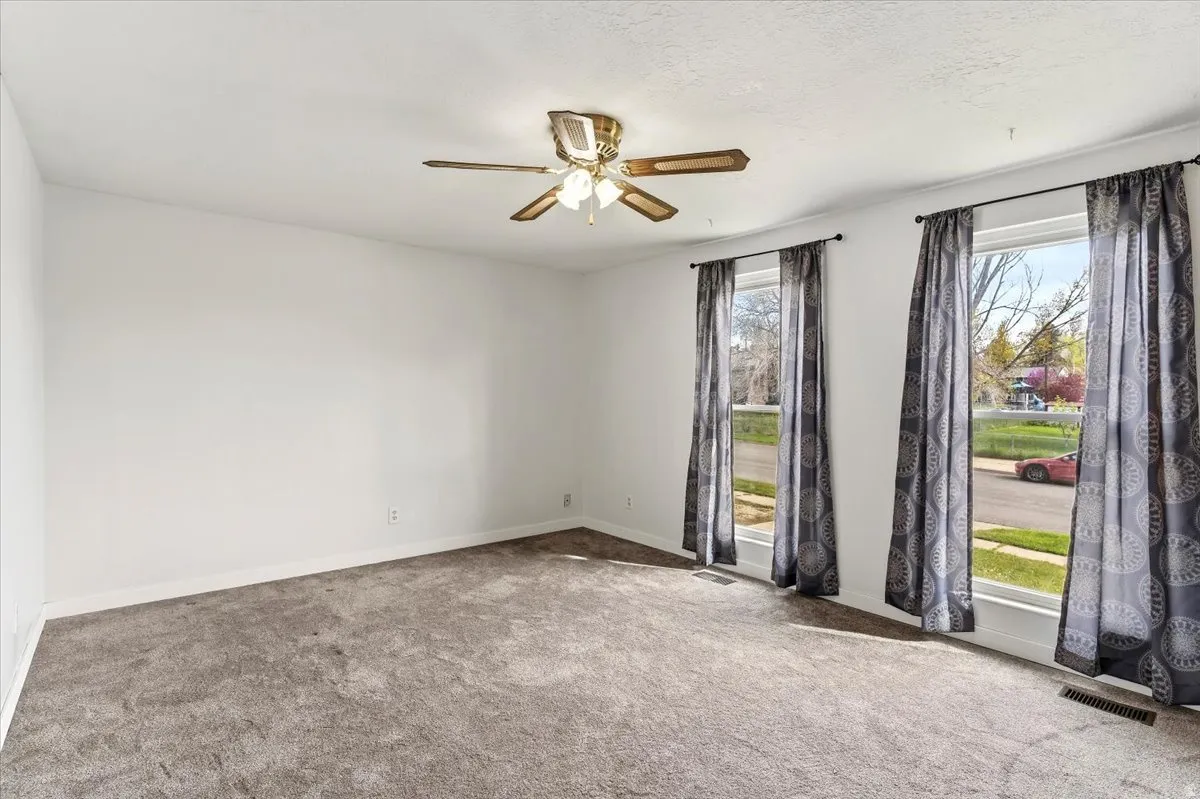 Empty room featuring carpet and ceiling fan
