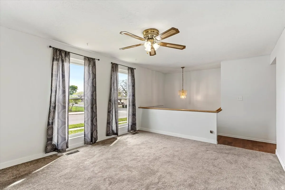 Empty room with carpet and a ceiling fan