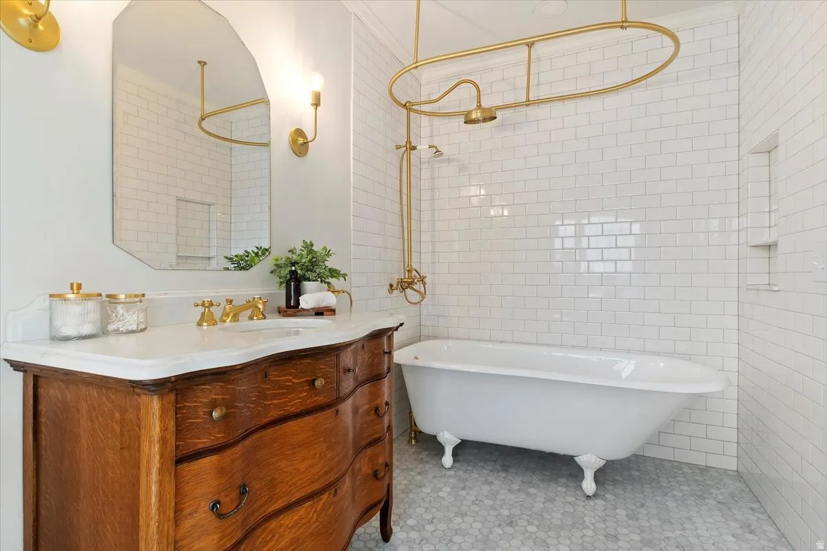 Full bath featuring vanity, tile walls, and a combined bath / shower with freestanding tub