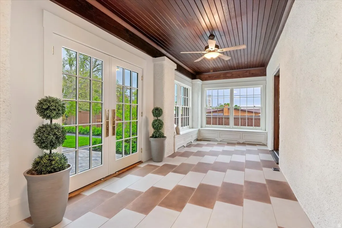 Unfurnished sunroom featuring french doors, wooden ceiling, and a textured wall