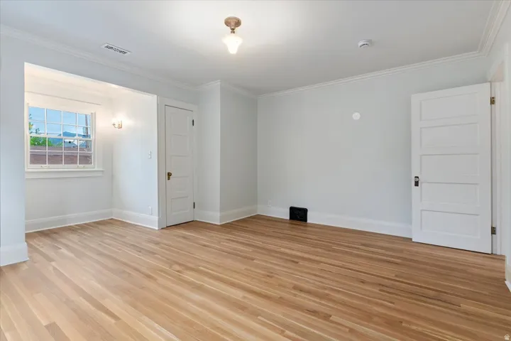 Unfurnished room featuring ornamental molding and light wood-style flooring