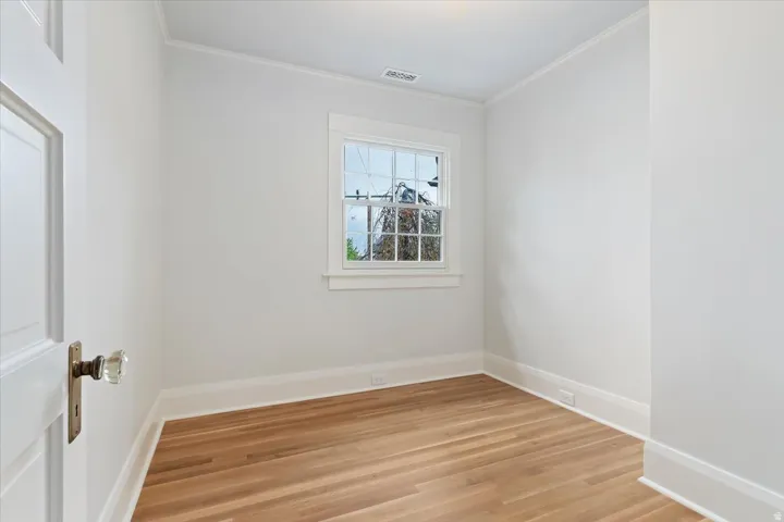 Empty room with light wood-style floors and ornamental molding