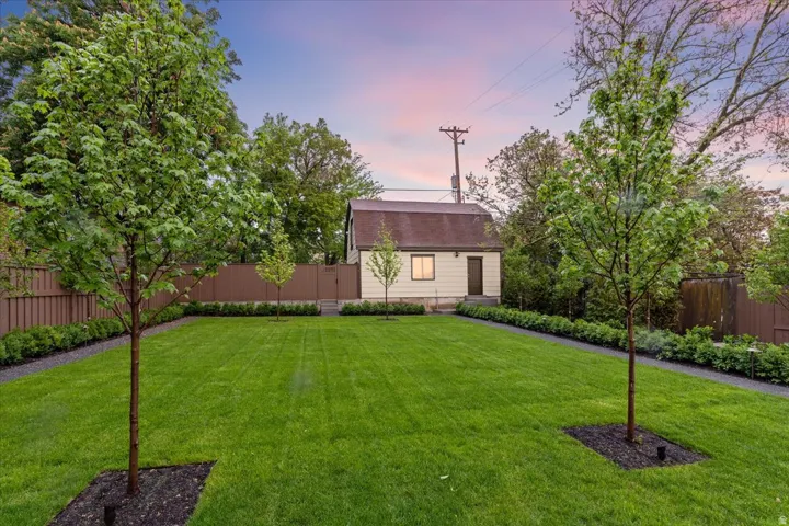 Yard at dusk featuring a fenced backyard