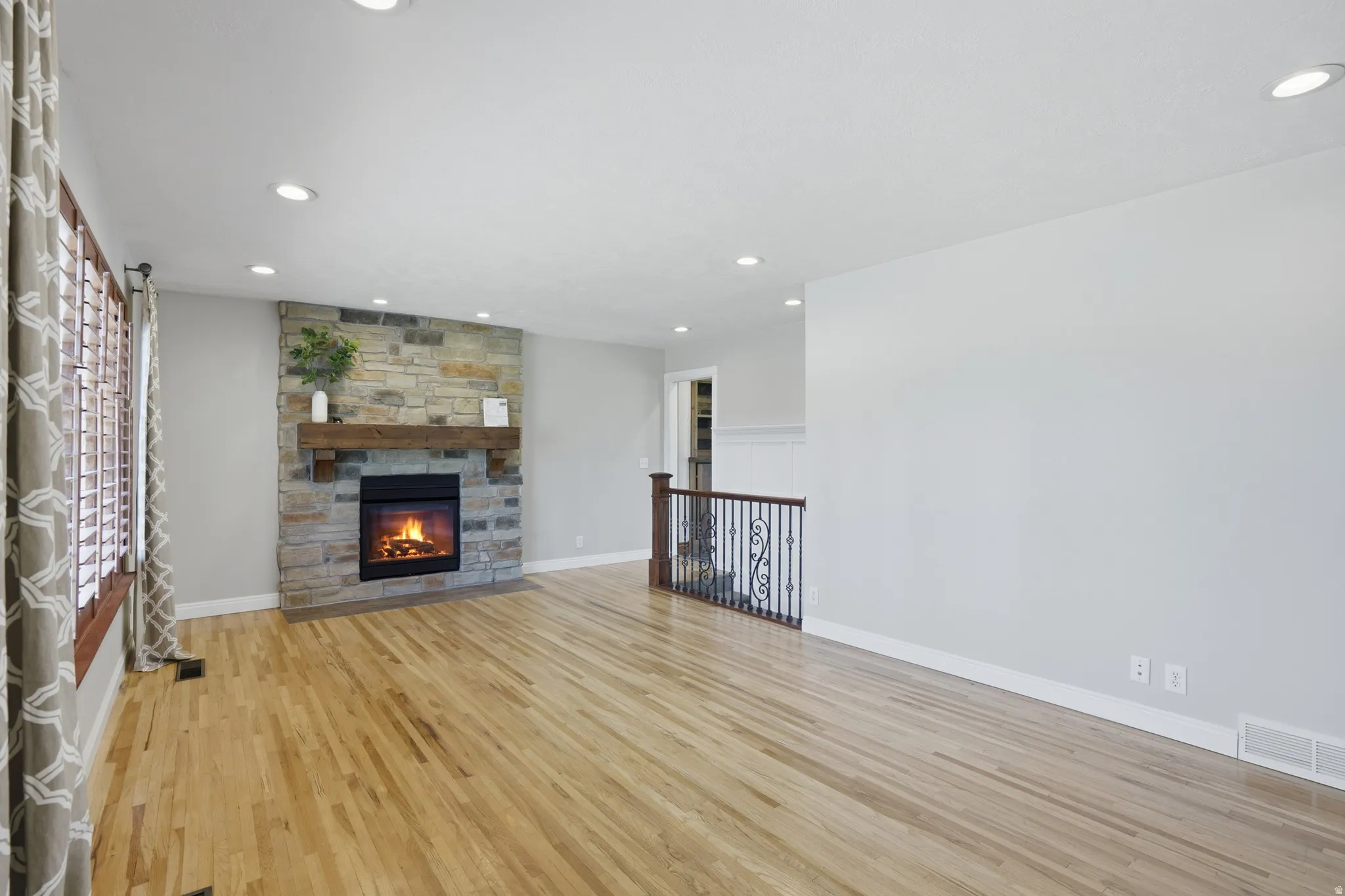 Living area featuring a stone-faced fireplace with a wood mantel