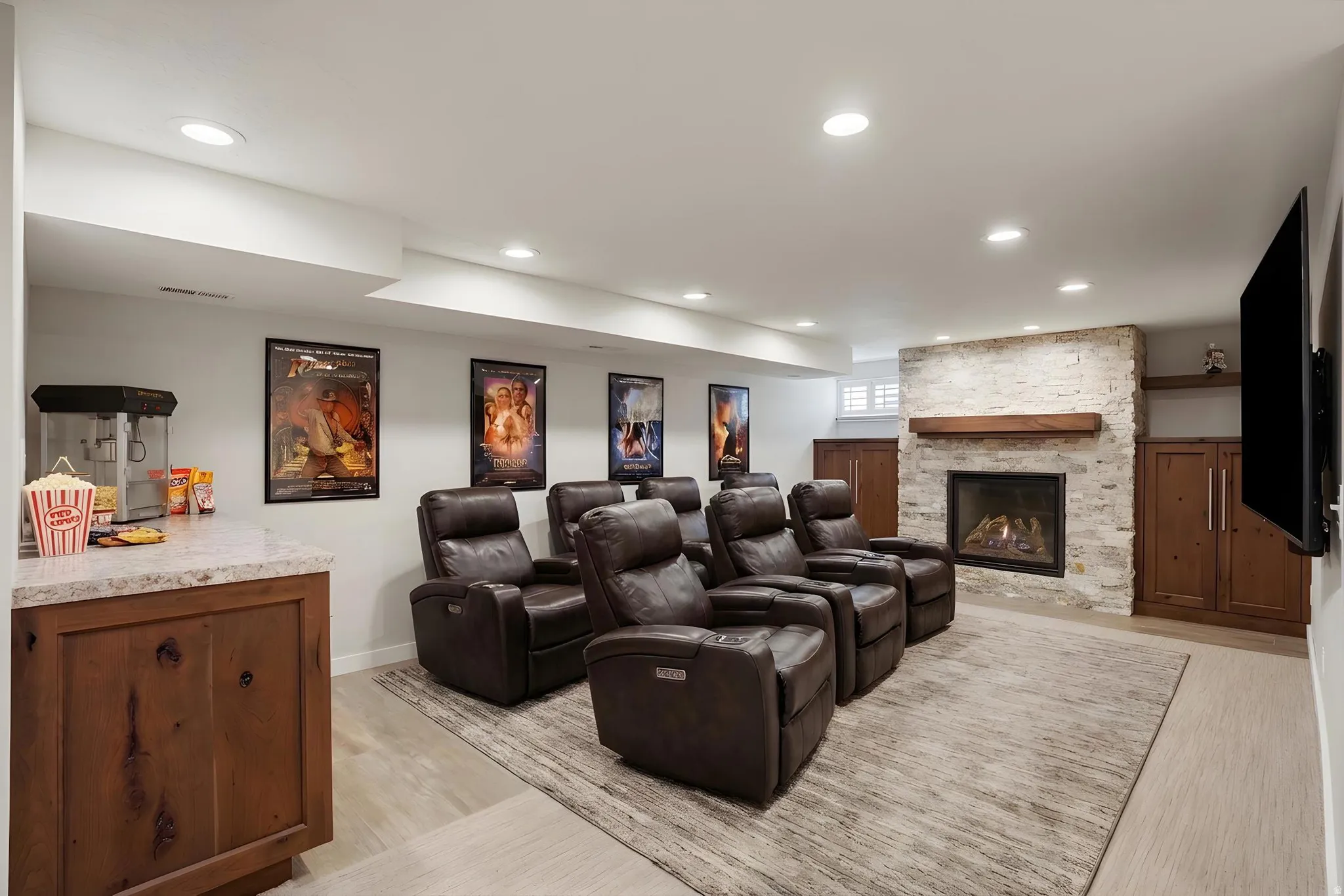 Home theater room with light wood-type flooring, a fireplace, and recessed lighting virtually staged.