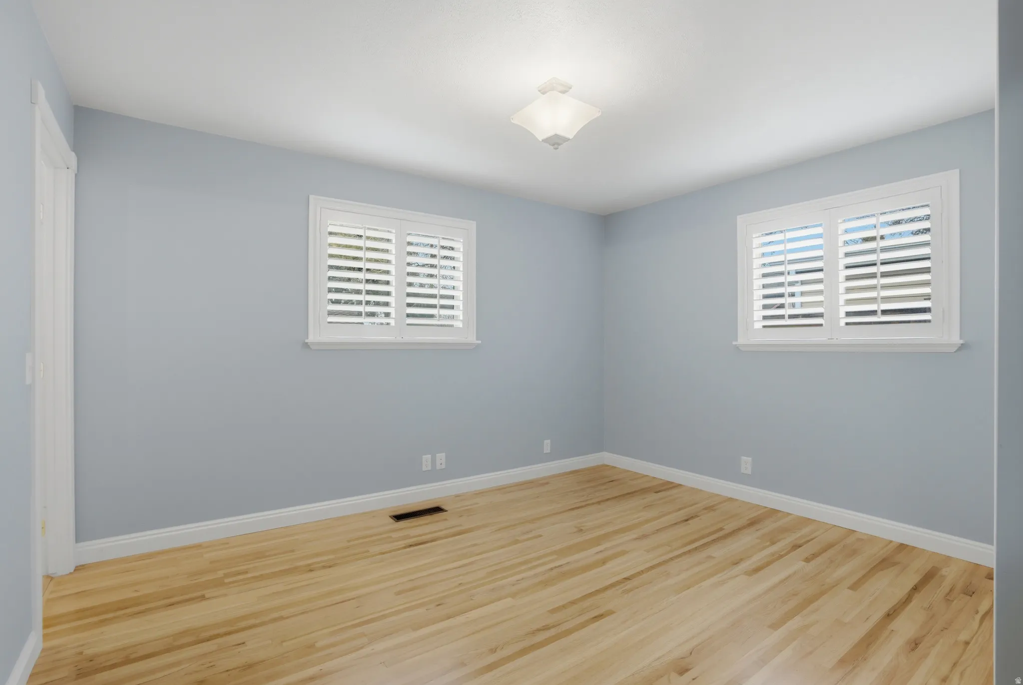 Spare room with light wood finished floors and healthy amount of natural light