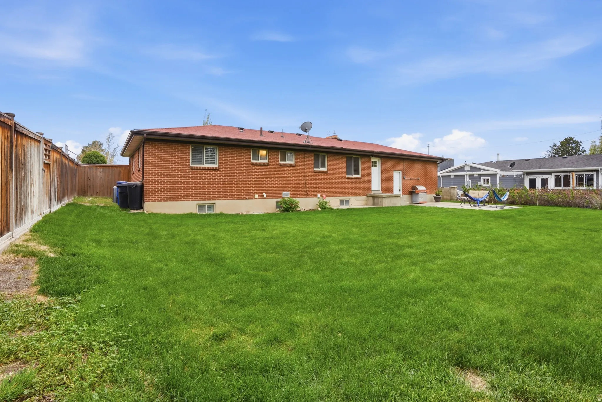Rear view of property featuring a fenced backyard, a patio, and brick siding