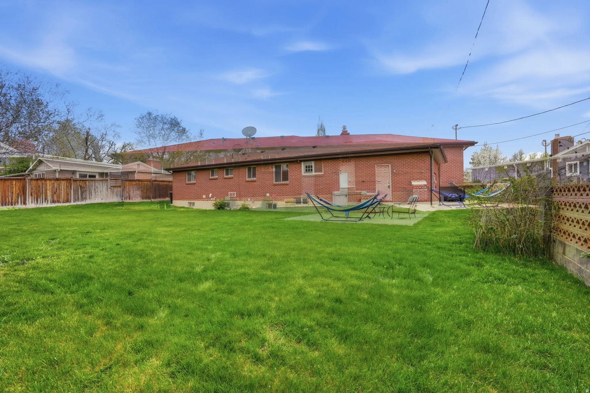 Back of house with a fenced backyard and brick siding