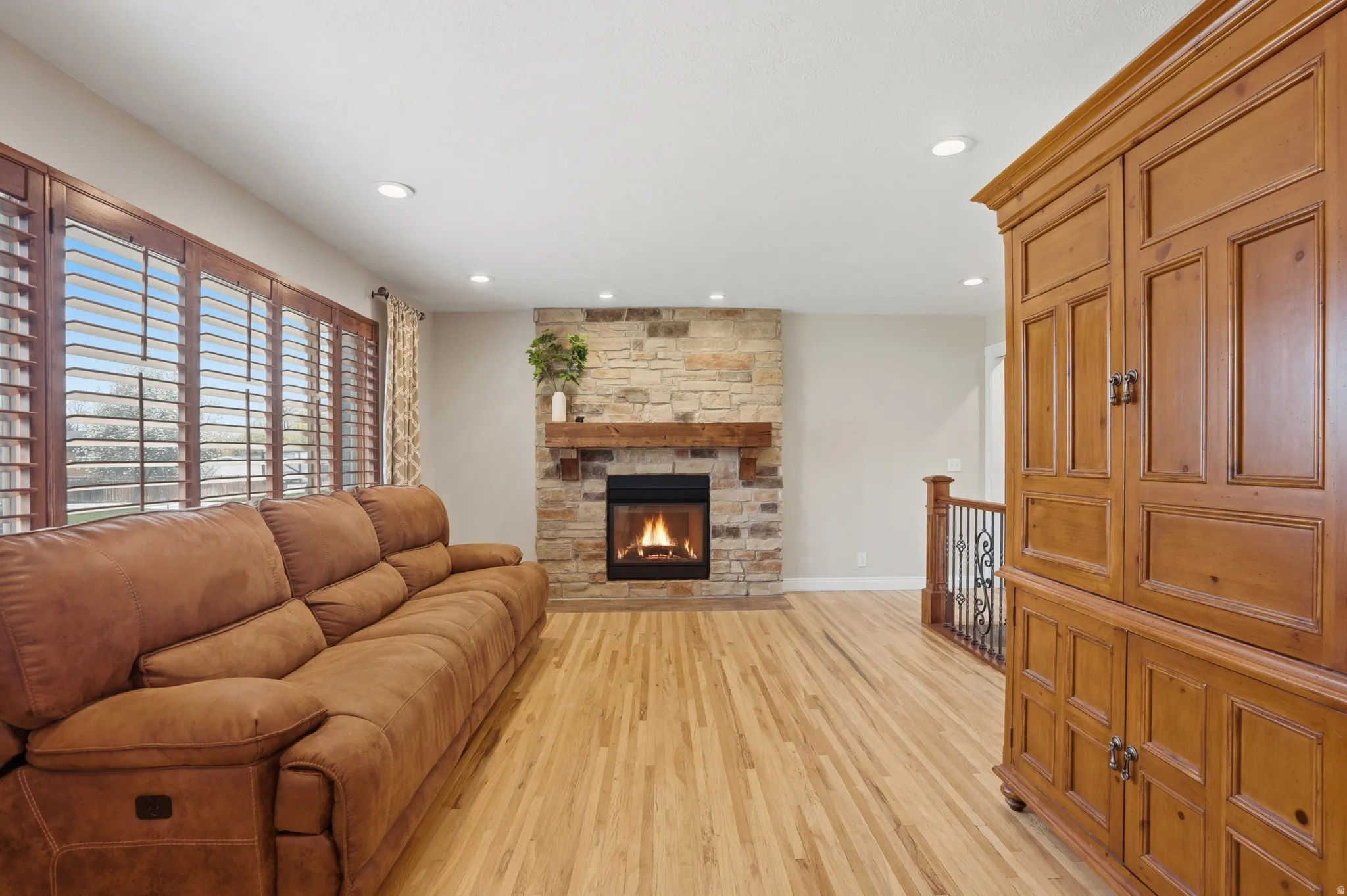 Living area featuring light wood-style floors, a fireplace, and recessed lighting