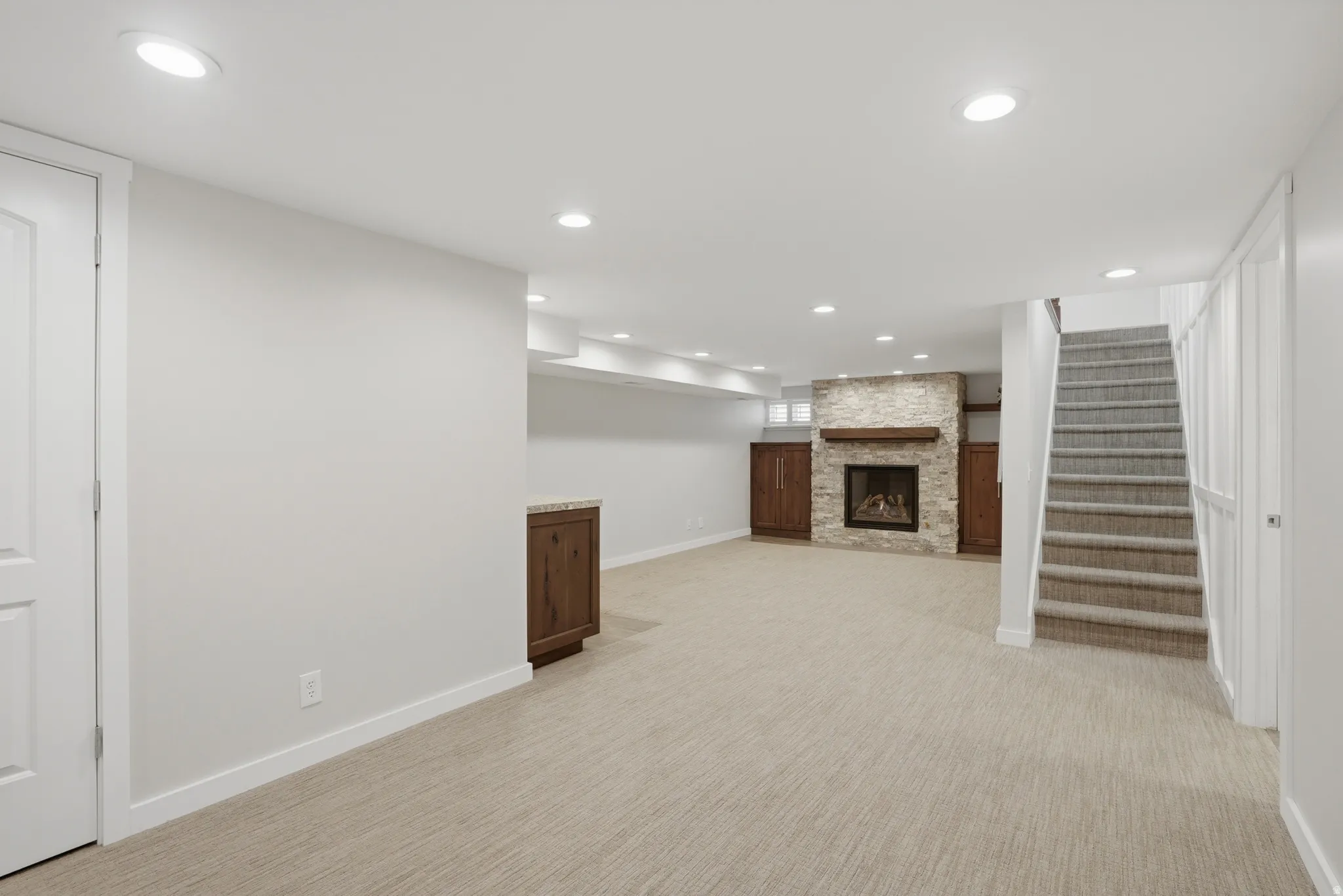 Finished below grade area featuring recessed lighting, a fireplace, and light colored carpet