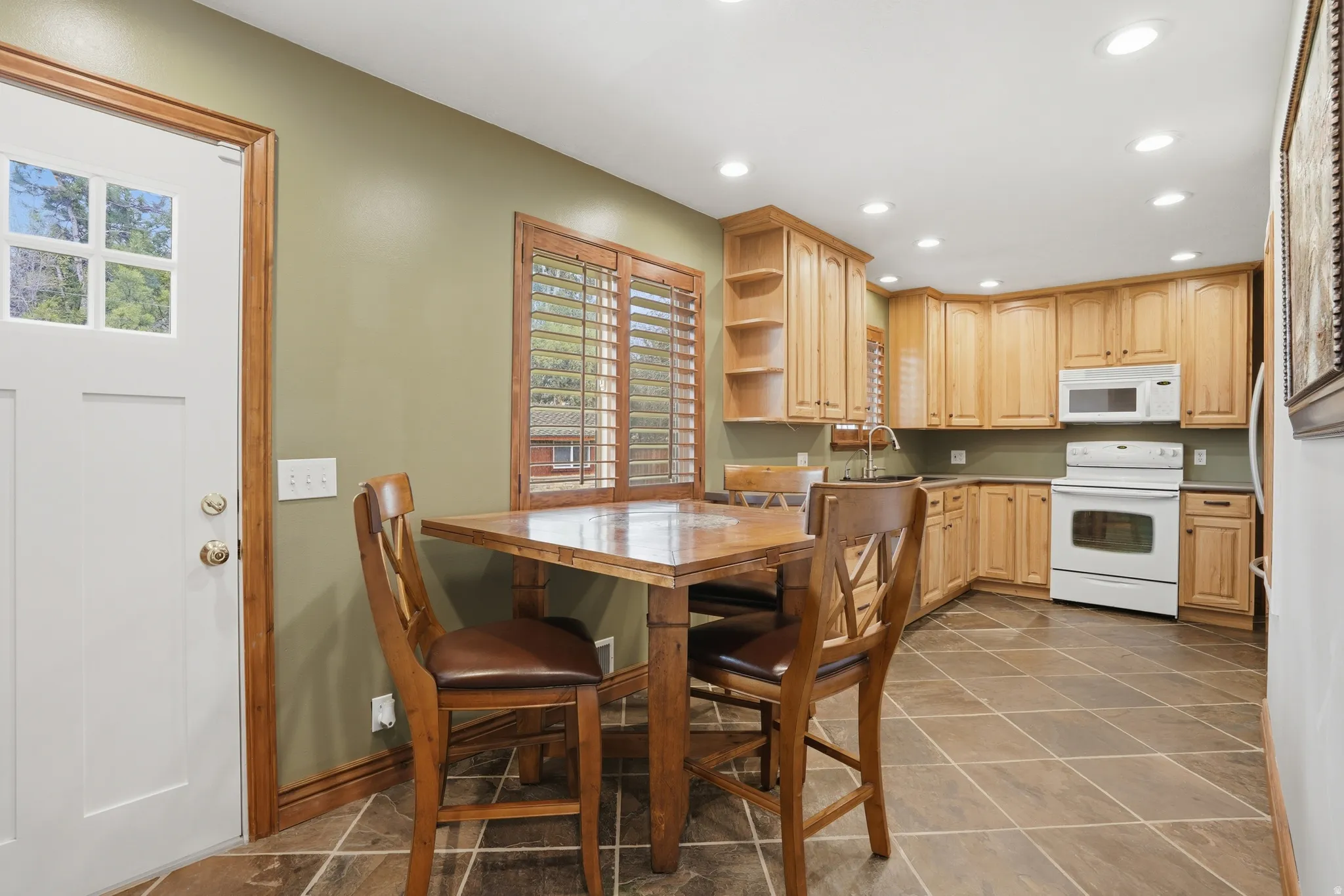 Kitchen featuring light wood finish cabinetry, white appliances, recessed lighting, open shelves, and light countertops