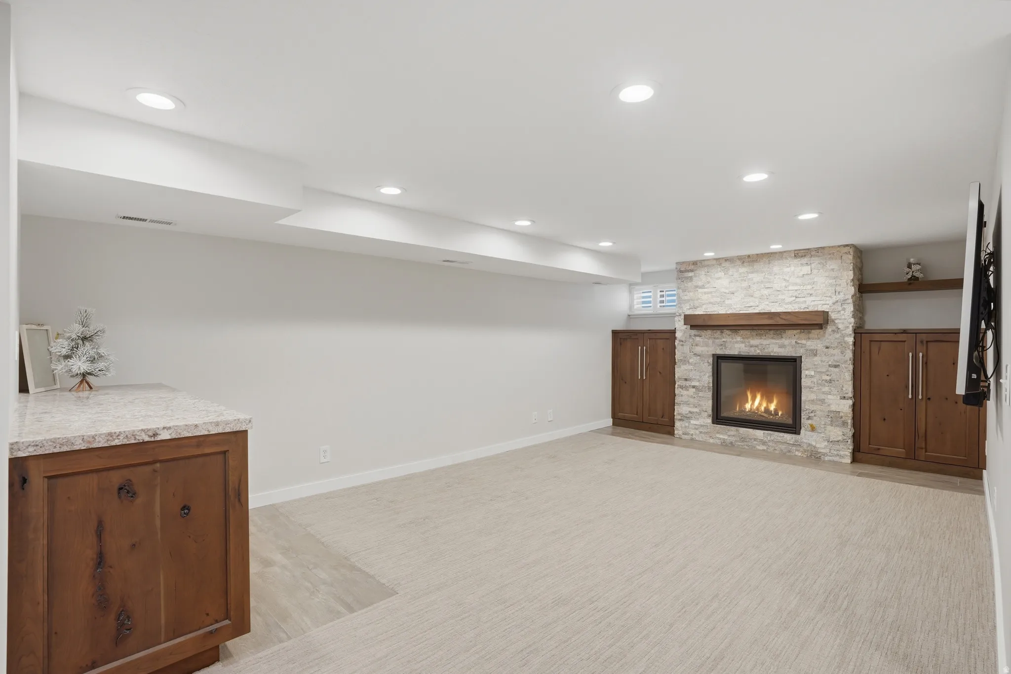 Unfurnished media room featuring a fireplace, light carpet, and recessed lighting