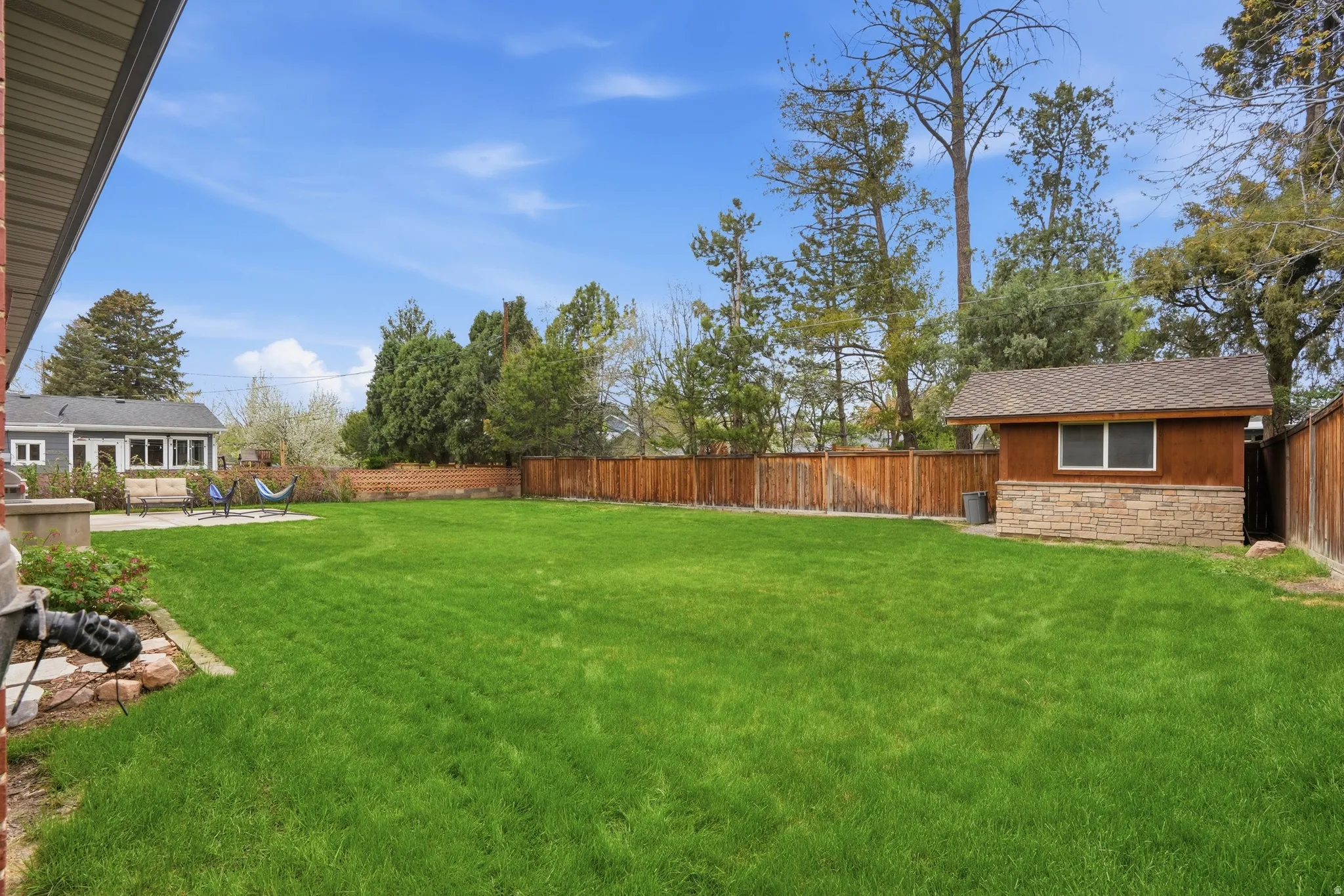 View of fenced backyard with shed (with power)