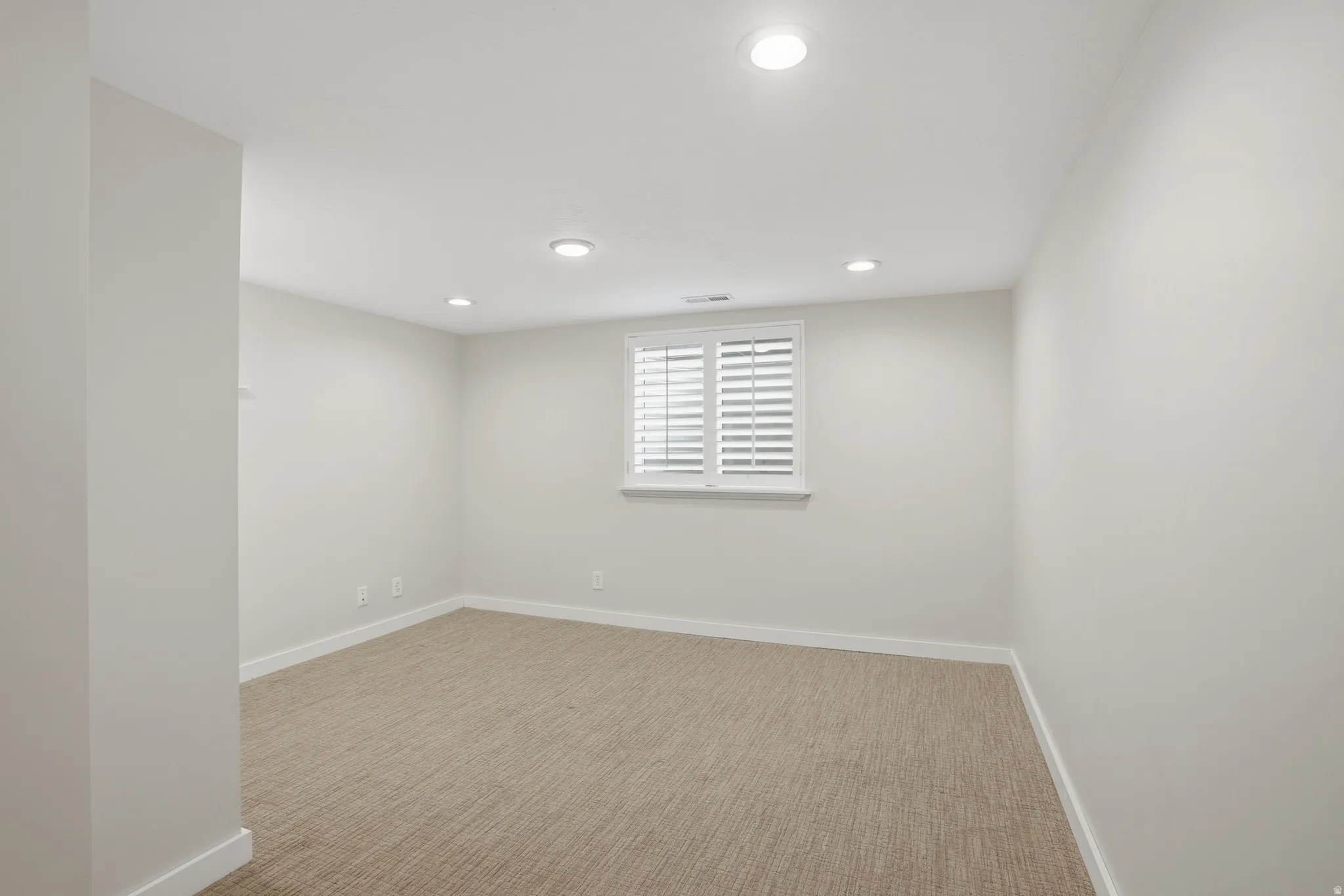 Carpeted bedroom with recessed lighting
