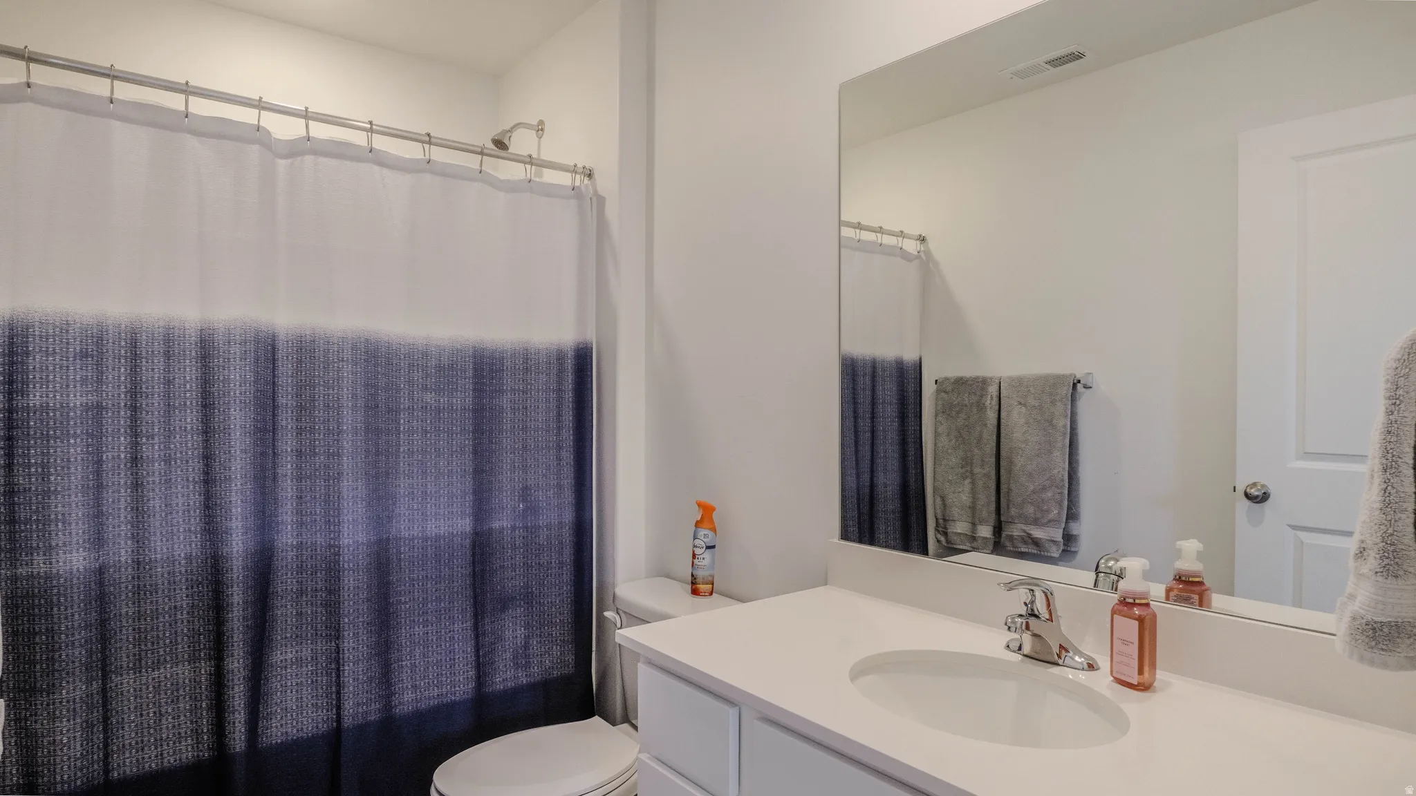 Full bath featuring vanity and shower / bath combination with curtain
