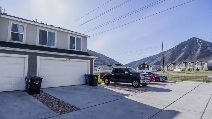 Garage with concrete driveway, a mountain view, and a residential view
