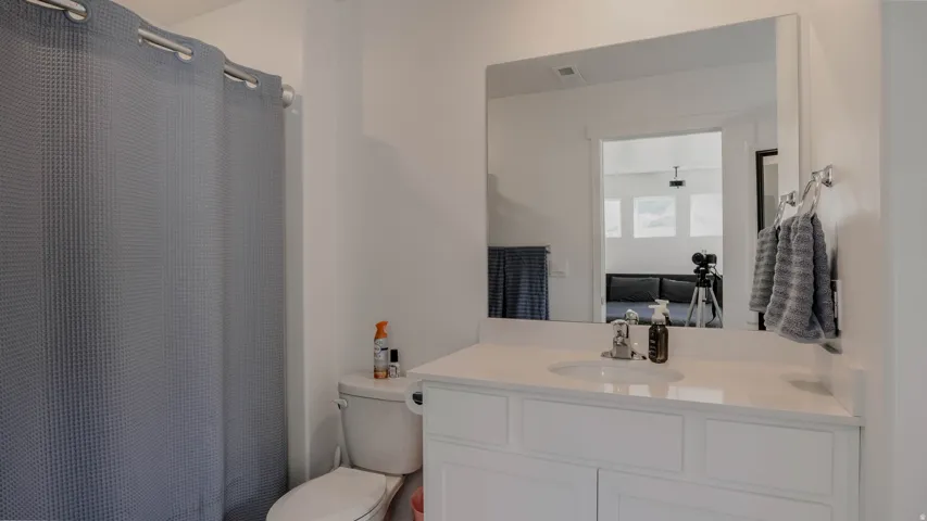 Full bath featuring vanity, curtained shower, and ensuite bath