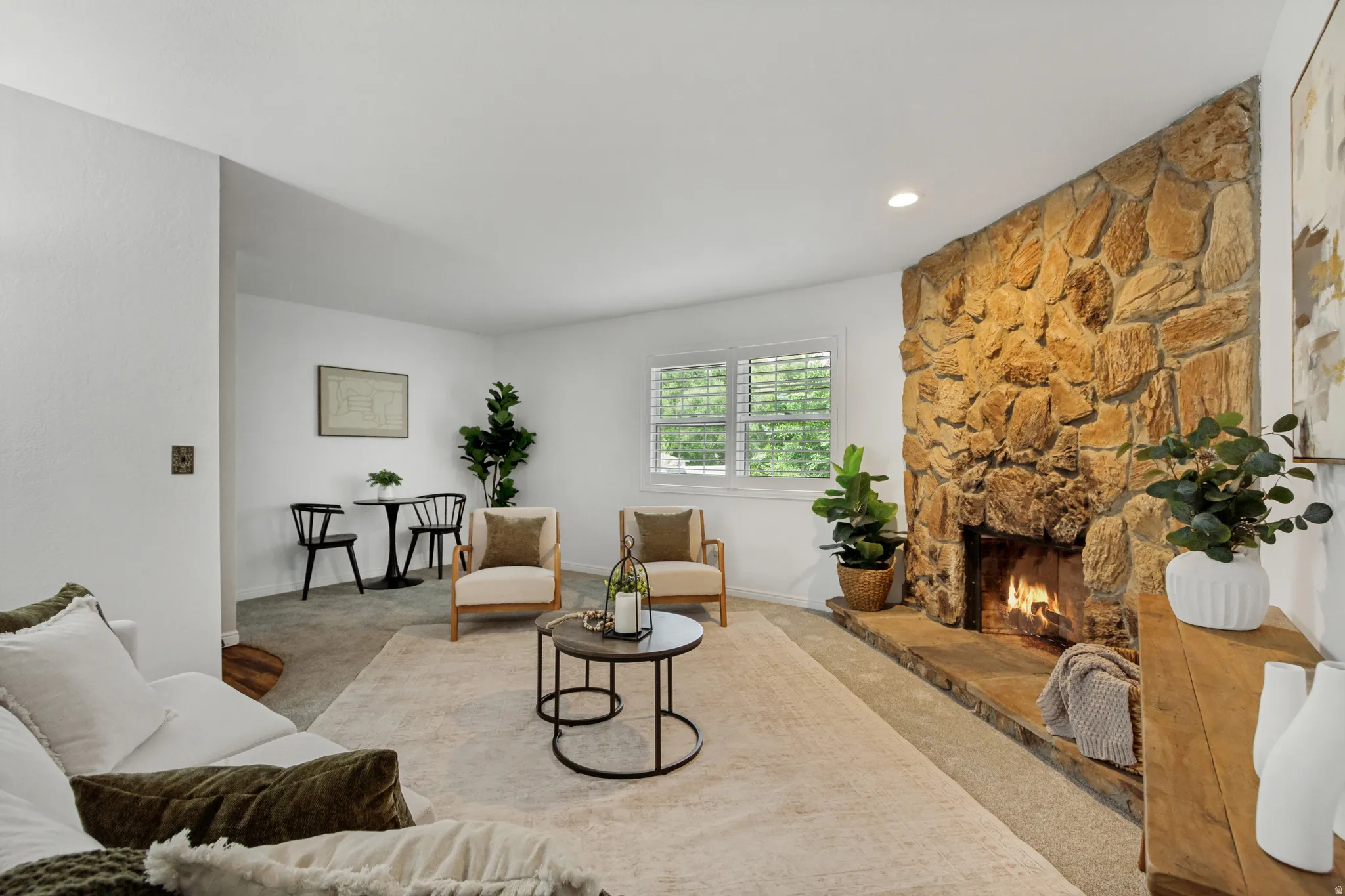Living area featuring a floor-to-ceiling stone fireplace with a stone hearth