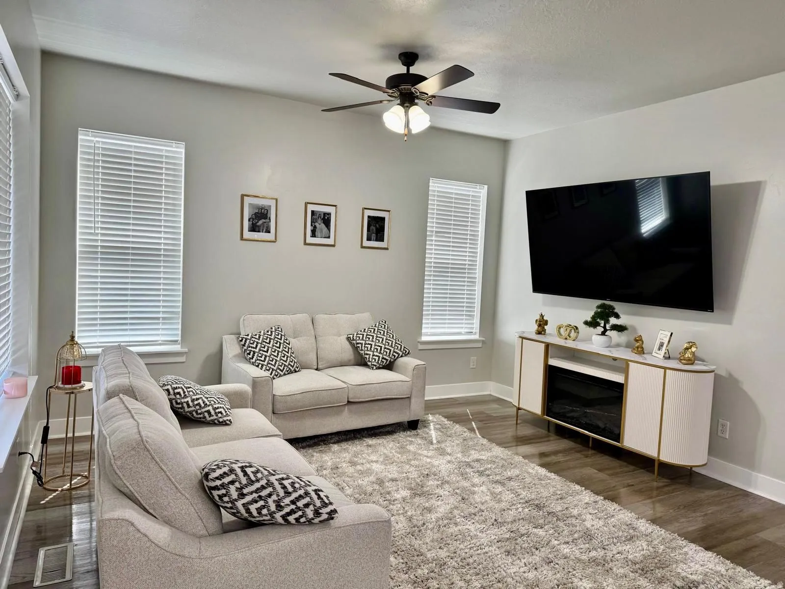 Living area with dark wood-type flooring and ceiling fan