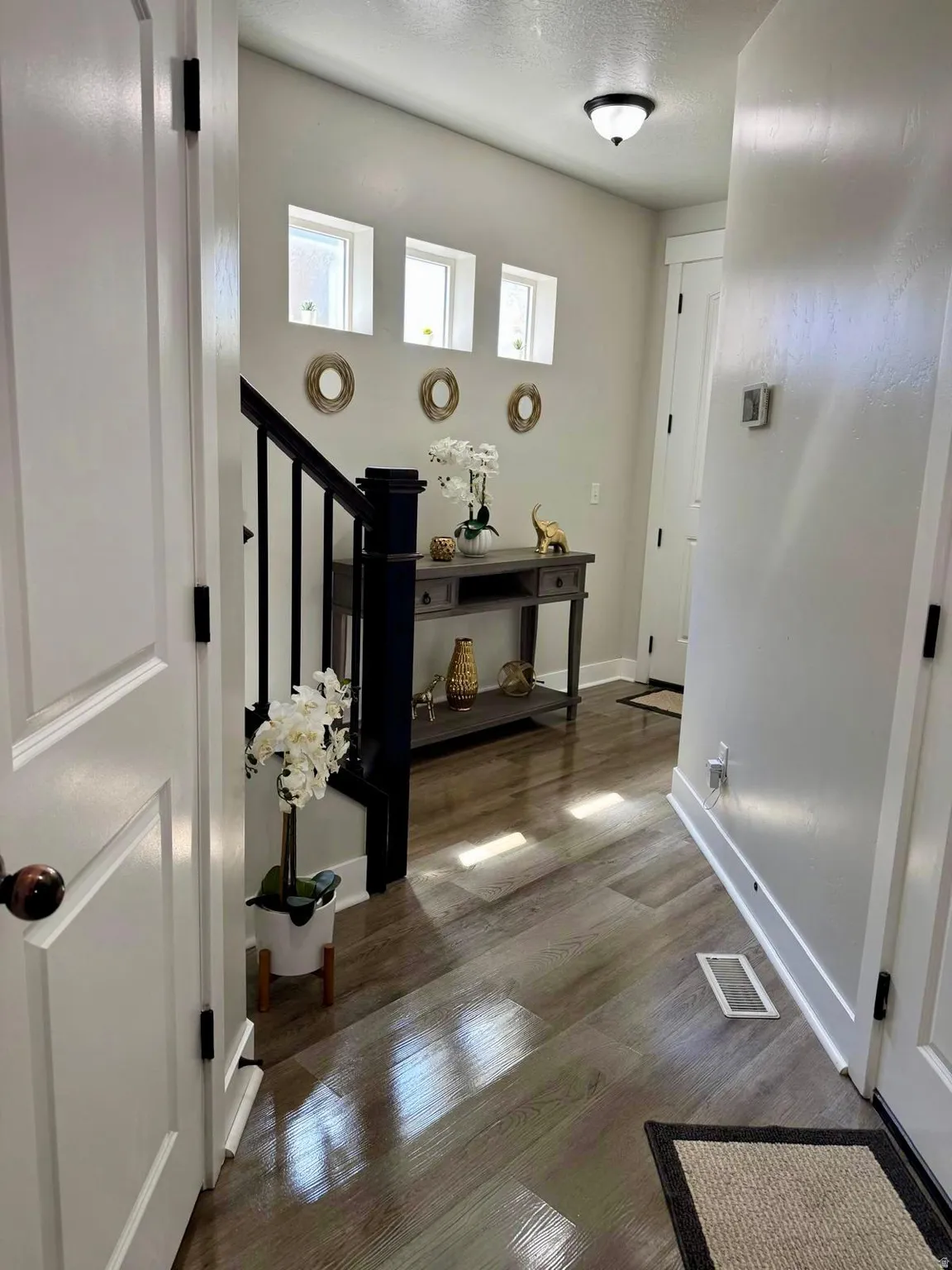 Hallway with dark wood-type flooring and a textured ceiling