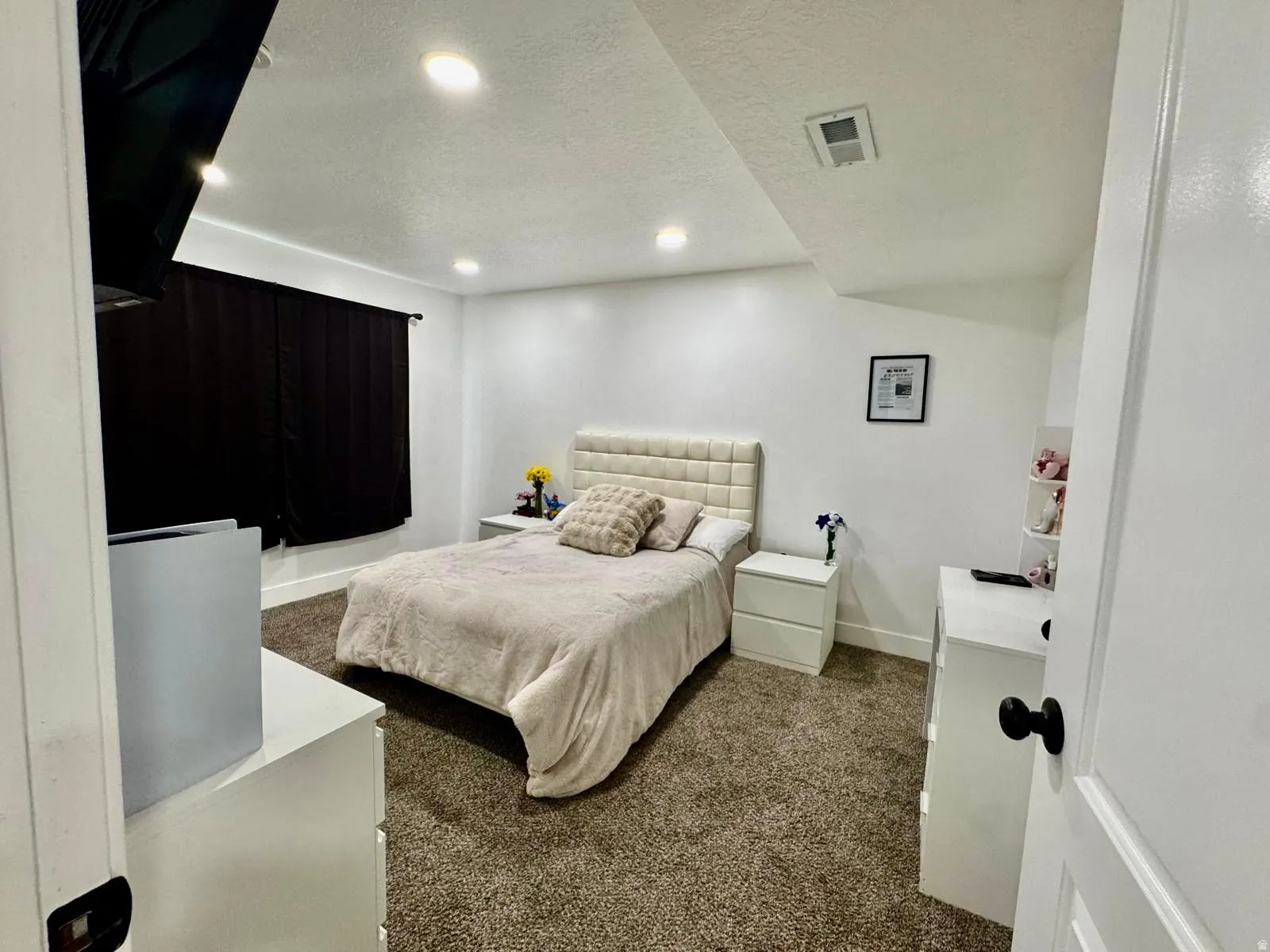 Bedroom featuring a textured ceiling, dark colored carpet, and recessed lighting