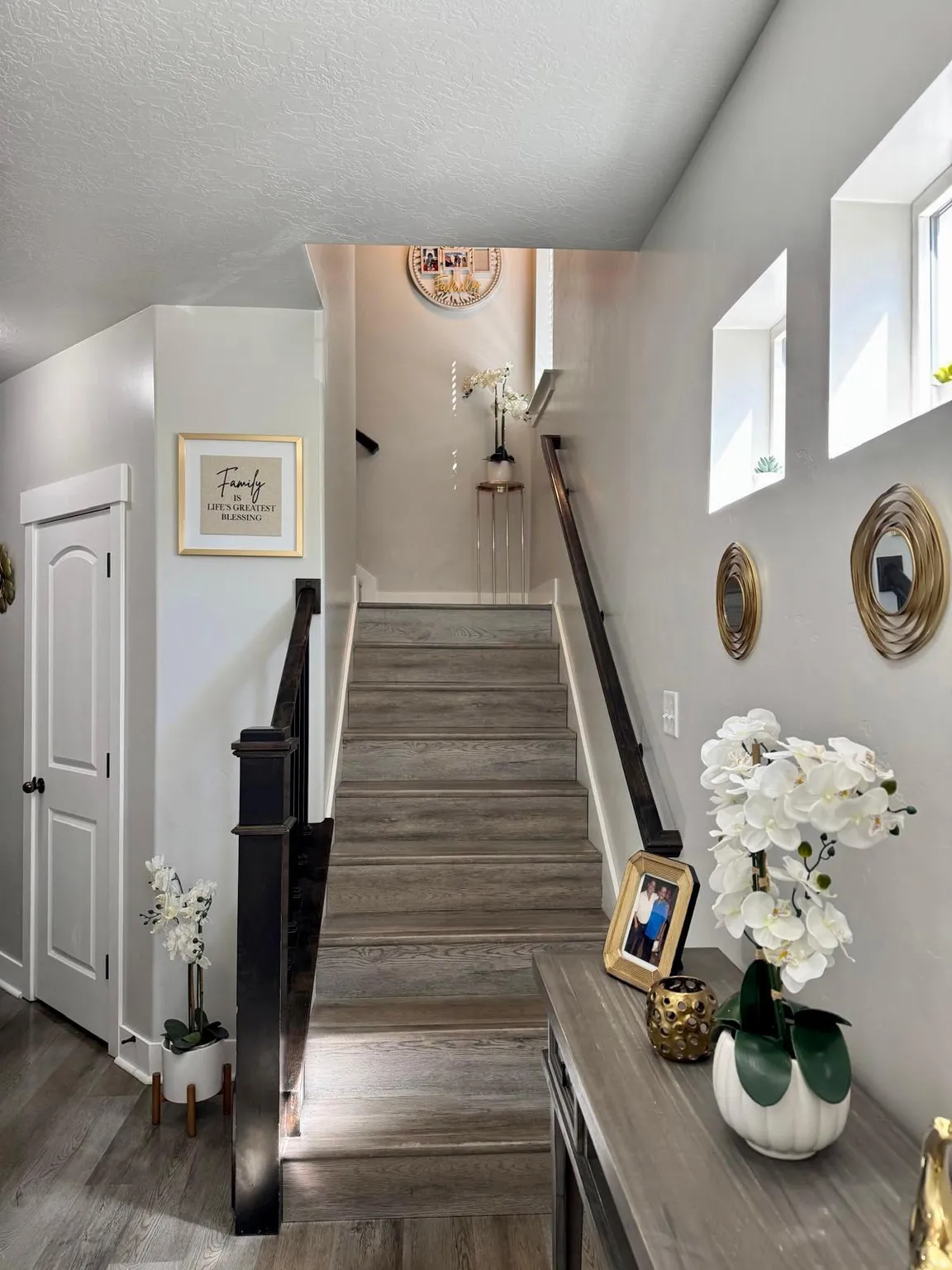 Stairway with wood finished floors and a textured ceiling