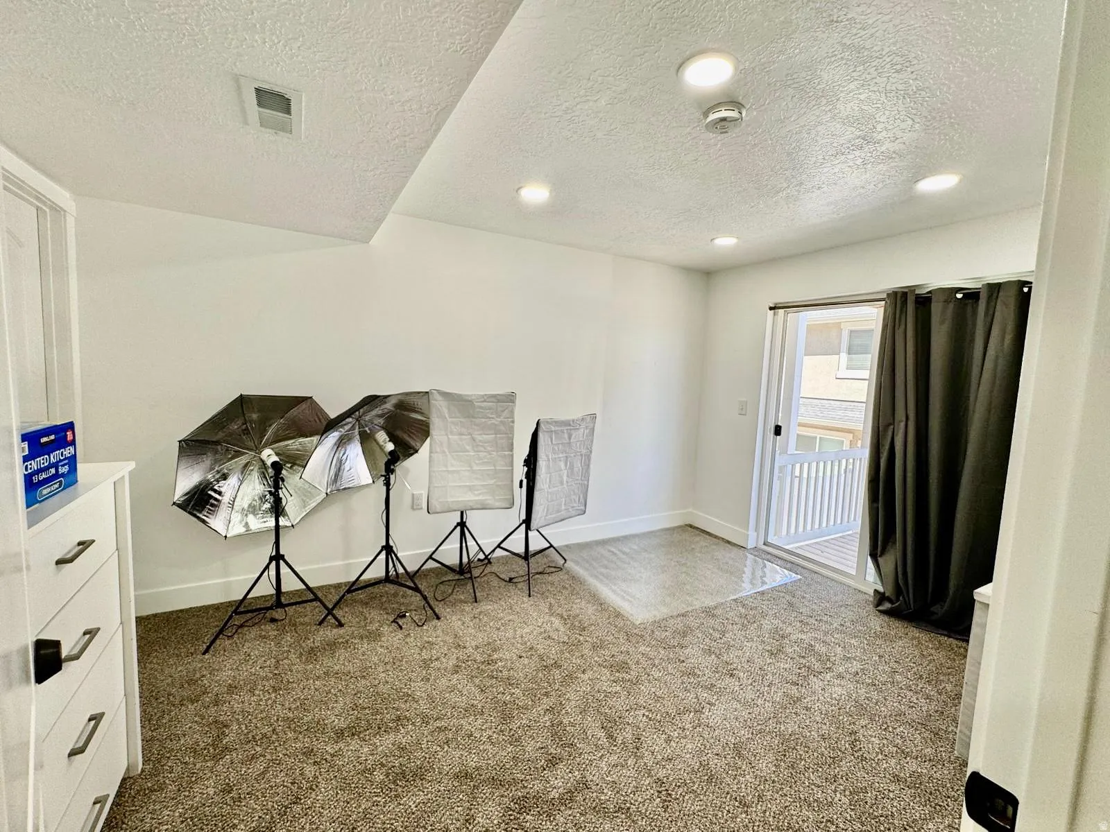Sitting room with a textured ceiling and light colored carpet